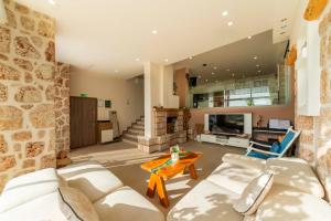 a living room with a white couch and a stone wall at Villa Panorama Kalkan Jilda Livya in Kalkan