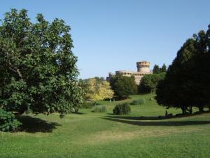 a park with trees and a building in the background at Appartamento i Priori in Volterra