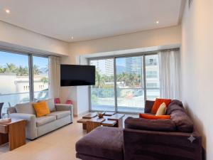 a living room with a couch and a tv at ICON Oceanview Retreat by Monyxbnb in Puerto Vallarta