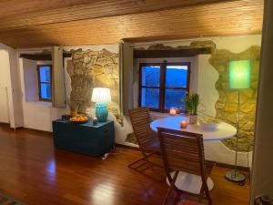 a room with a table and chairs and a stone wall at Villa Chicca in Neviano degli Arduini