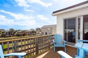 a balcony with blue chairs and a table and a view at 6150 - B Groove Inn (formerly Pelican Crest) in Nags Head