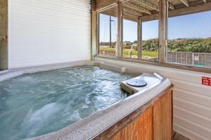 a hot tub in a house with windows at 6150 - B Groove Inn (formerly Pelican Crest) in Nags Head