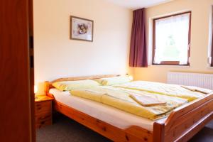 a bedroom with a wooden bed with a window at Haus Keller Ferienwohnungen in Todtnauberg