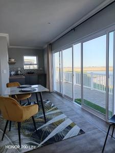 a living room with a table and chairs and a large window at Weskusbokkompie in Velddrif