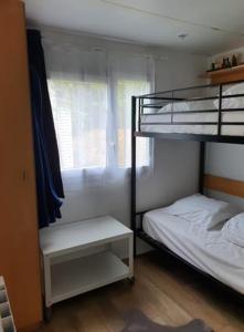 a bedroom with two bunk beds and a window at Mobile Home in Morbier