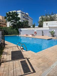 a swimming pool with blue water in a building at Chipiona CERCA DE LA PLAYA in Chipiona