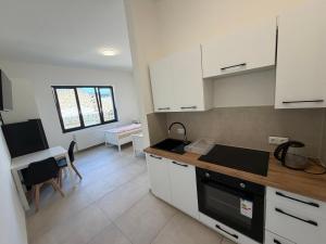 a kitchen with white cabinets and a table and a desk at Private Room in Hannover