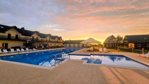 a large swimming pool with a sunset in the background at Stilo Country in Wolin
