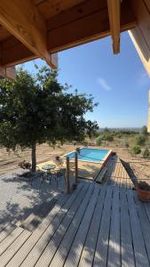 a wooden deck with a table and a swimming pool at Chalé da Cumieira Nova in Seia