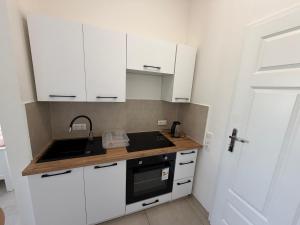a small kitchen with white cabinets and a sink at Private Room in Hannover