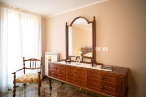 a bathroom with a dresser with a mirror and a chair at La Dimora Sulla Collina Micciani Rieti in Micciani +15 photos
