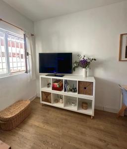 a living room with a tv on a white cabinet at CasaGerman in Sierra Nevada