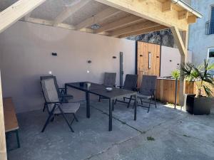 a patio with a wooden table and chairs at Pension zum Kanal in Burg bei Magdeburg
