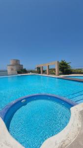 a large swimming pool with blue water at PREMIUM Puerto Varadero Apartamento con Vista al Mar y Planta Total in Tucacas