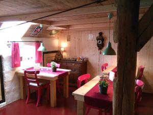 una cucina con sedie rosa e un tavolo in una stanza di B&B De Luttikhoeve a Giethmen