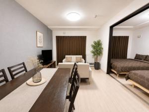 a living room with a dining table and a bedroom at Excel 美園 -FIX HOME- in Sapporo