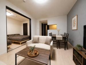a living room with a couch and a table at Excel 美園 -FIX HOME- in Sapporo