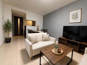 a living room with a couch and a tv at Excel 美園 -FIX HOME- in Sapporo