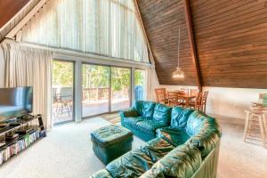 a living room with a couch and a television at Charming, lakefront A-frame with private dock, lakeside gazebo, spacious deck in Bumpass