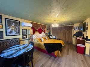 a bedroom with a bed and a table in it at Historic Ziegler Inn and Suites with Whimsical Themed Rooms in New Bern