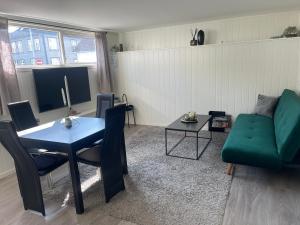 a living room with a green couch and a table at Stavanger BnB 4 by Sidd in Stavanger
