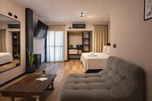 a living room with a couch and a bed at Terra Firma Hotel Boutique in Villa Carlos Paz