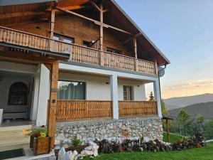 a large house with a balcony on top at Casa din fagi in Munună