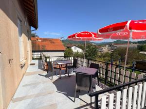 a balcony with a table and chairs and an umbrella at Appartement spacieux et lumineux proche gare in Ambérieu-en-Bugey