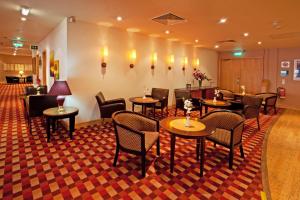 a waiting room with tables and chairs in a hotel at Britannia Hotel Bolton in Bolton
