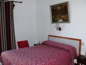 a bedroom with a red bed and a red chair at Casa Mariana in Almuñécar