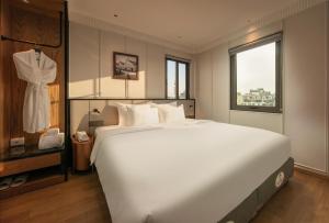 a bedroom with a large white bed and a window at Hoan Kiem Legends Hanoi Hotel in Hanoi +67 photos