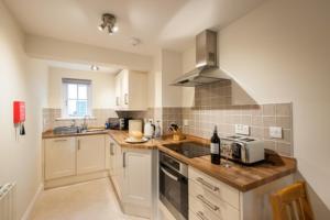 a kitchen with a sink and a stove top oven at Milntown Self Catering Apartments in Ramsey