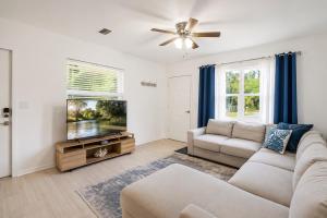 a living room with a couch and a flat screen tv at The Crystal River House in Crystal River
