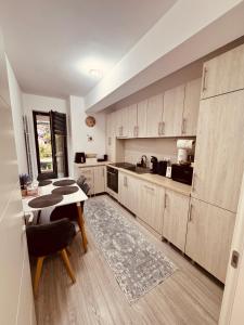 a kitchen with wooden cabinets and a table in it at A B V Central Apartment- Unitate autorizata de Ministerul Turismului in Râmnicu Vâlcea