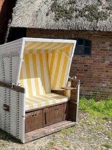 a yellow and white chair sitting in front of a building at Emes Stuuv in Oevenum