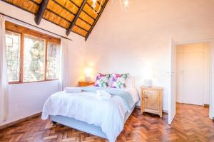 a bedroom with a bed and a wooden floor at Ambleside Cottage in Underberg