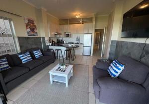 a living room with two couches and a table at Kei Sands Nr 6 in Kei-mouth Village