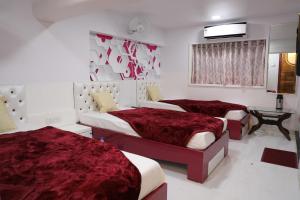 ナビムンバイにあるHotel Pearlの赤いシーツが備わるドミトリールームのベッド2台分です。