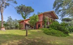 a red house in the middle of a field at Casa Natura Flassia de 240m2 con piscina privada in Vidreres