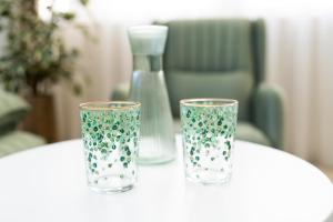 a table with two glasses and a vase on it at Dream Palace 2 in Belgrade +6 photos