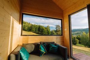 a couch in a room with a large window at Tiny House Dolinky in Veľká Lesná +11 photos