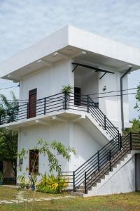 a white house with stairs on it at Villa Downsouth Nilaveli in Kumpurupiddi