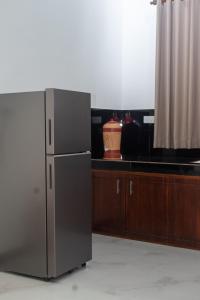 a kitchen with a stainless steel refrigerator next to a counter at Villa Downsouth Nilaveli in Kumpurupiddi