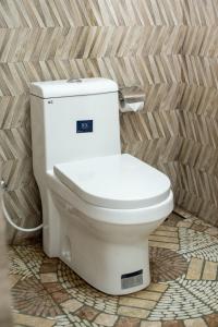 a white toilet in a bathroom with a wall at Villa Downsouth Nilaveli in Kumpurupiddi +33 photos