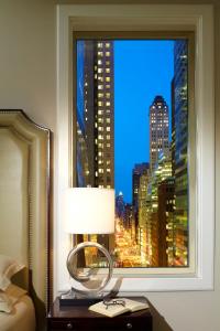 a bedroom with a window with a view of a city at Omni Berkshire Place in New York