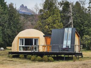 a yurt in a field with a mountain in the background at Glamping Vulcanche in Villa Traful