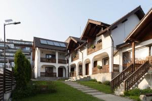 a row of houses with balconies and a yard at Pensiunea Encian in Colibiţa