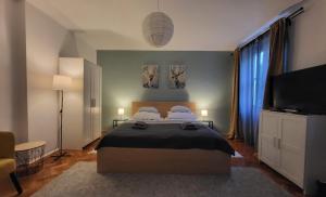 a bedroom with a bed and a flat screen tv at Tornyai Apartman in Hódmezővásárhely
