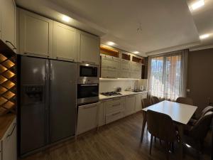 a kitchen with a black refrigerator and a table at Villa Kazbegi in Tkarsheti