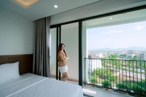 a woman standing on a balcony in a hotel room at Thành Danh Hotel in Dong Hoi +57 photos